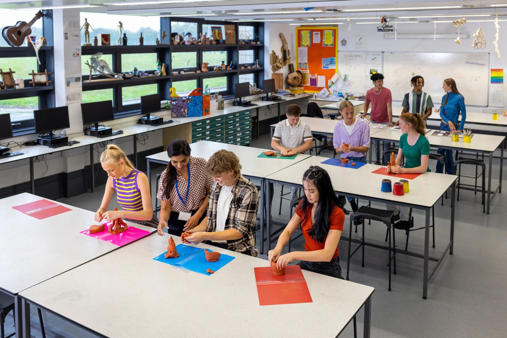 Teacher guiding students during a hands-on art class